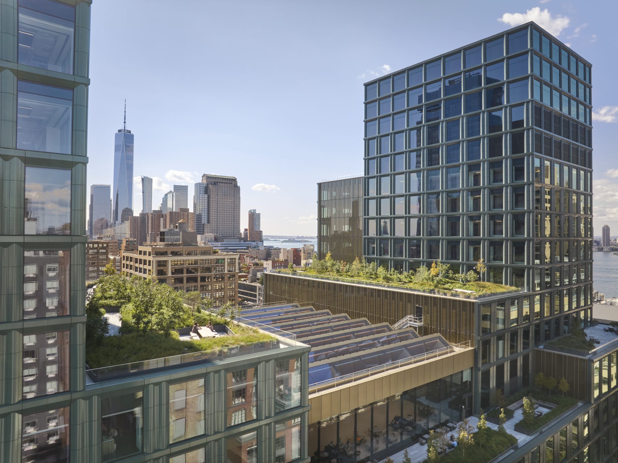 The Walt Disney Company's New York headquarters campus with rooftop terraces, with the lower Manhattan skyline and One World Trade Center in the background