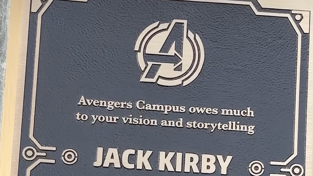 Jack Kirby plaque at Avengers Campus at Disney California Adventure, with the Avengers logo and the dedication line Avengers Campus owes much to your vision and storytelling