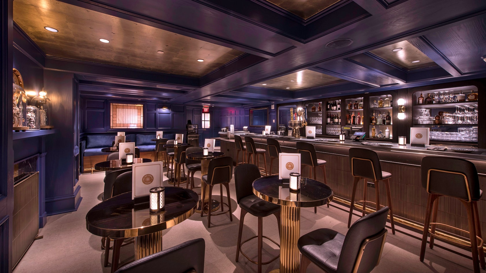 A lounge area with a bar, tables and seats