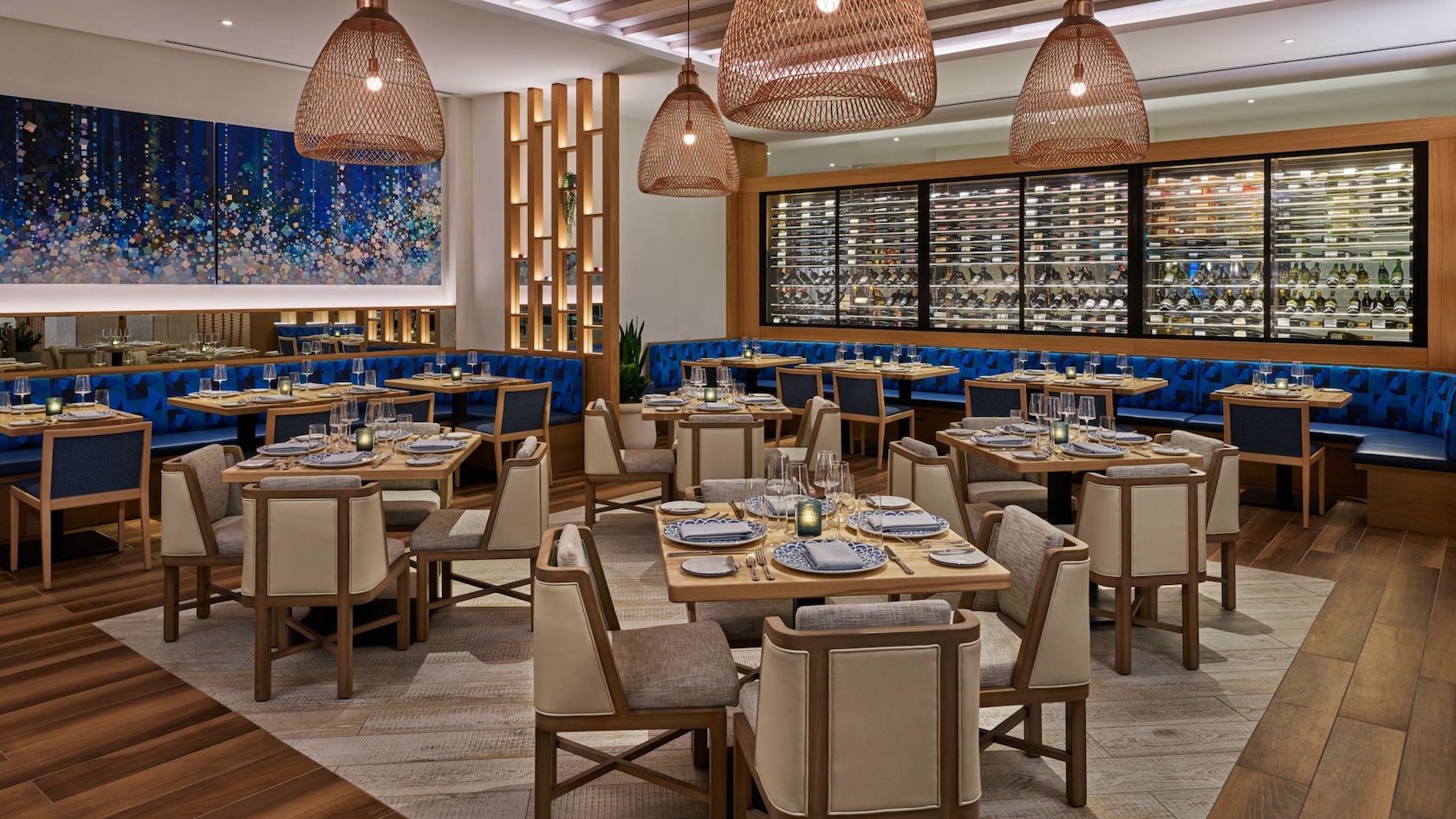 A dining area in Amare restaurant at Walt Disney World Swan Reserve with a glass wine display