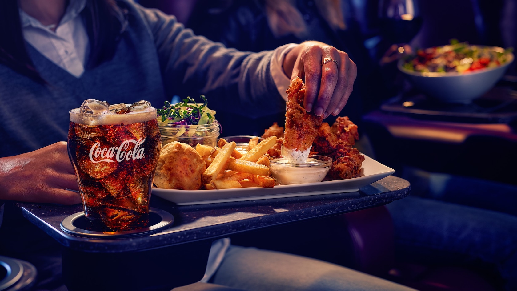 Guests enjoy plated food and drinks in an AMC Disney Springs 24 Dine In Theatre
