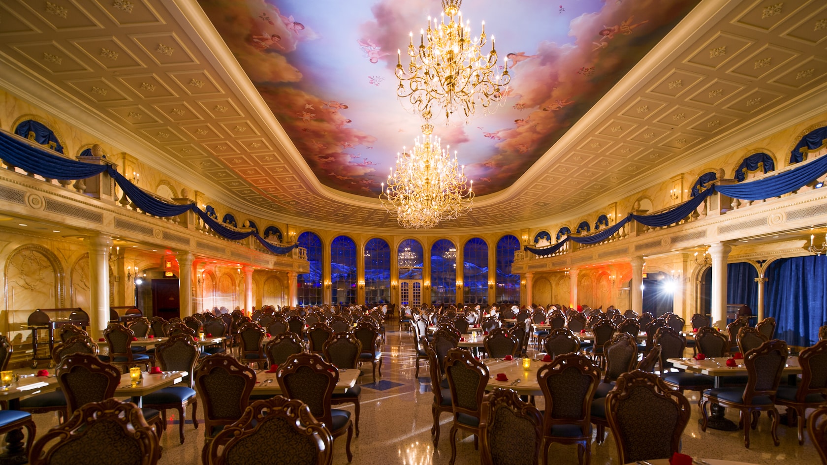 Two large chandeliers hang above the dining room at Be Our Guest Restaurant in Magic Kingdom