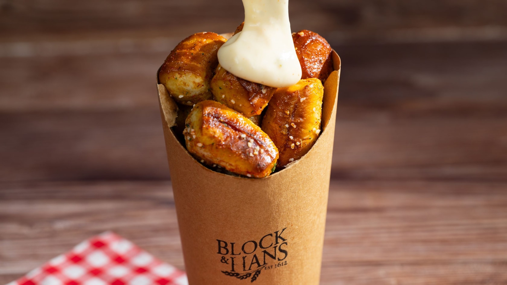 Pretzel Nuggets from Block & Hans being topped with a beer cheese sauce