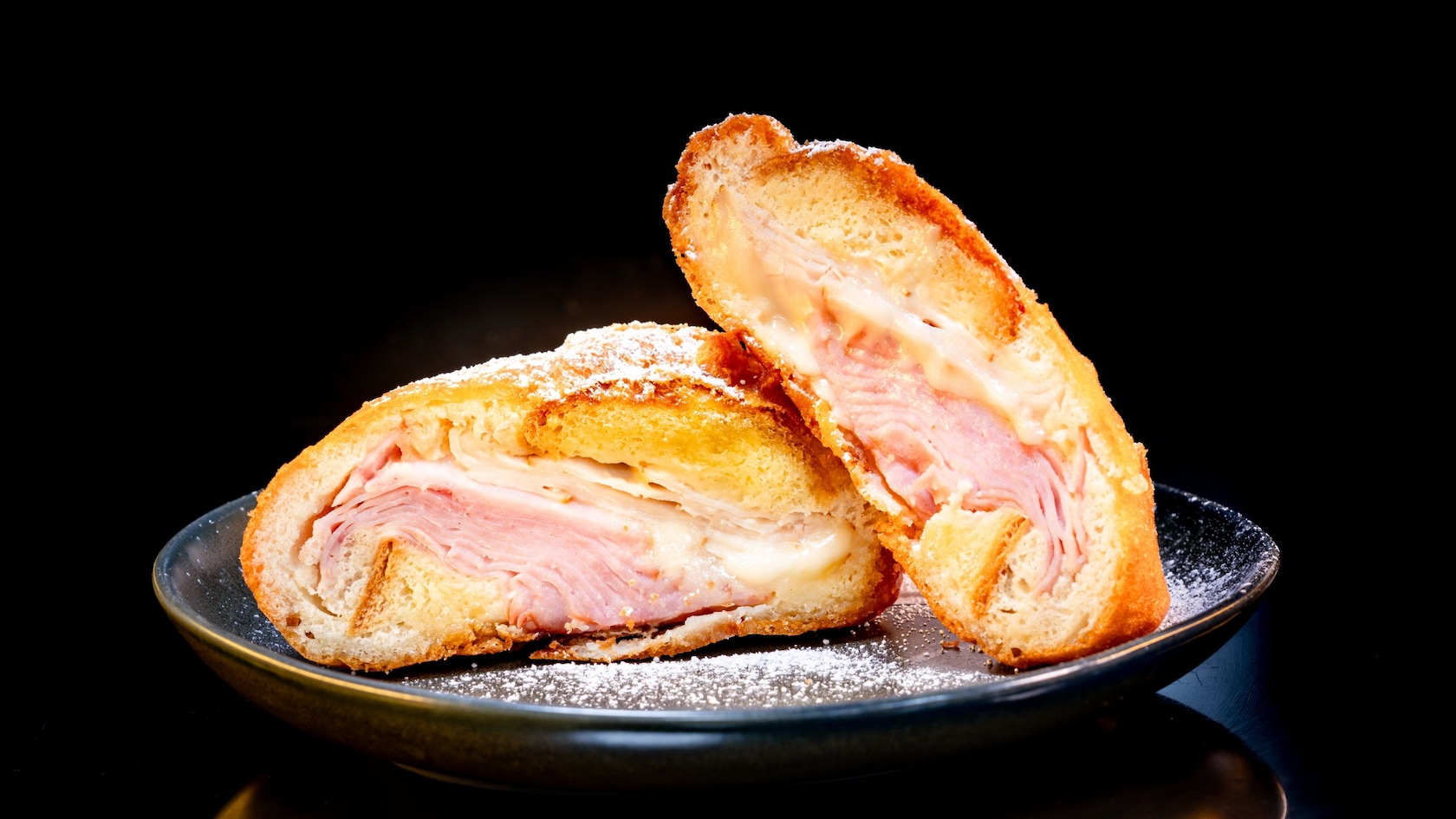 A Monte Cristo sandwich with ham and cheese cut in half