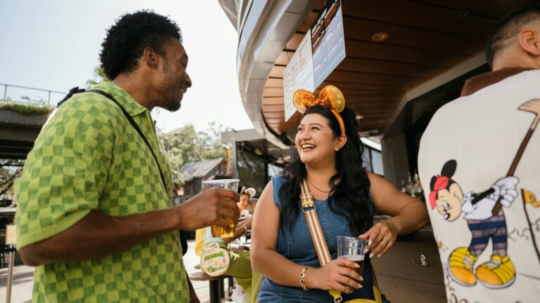 A man and a woman chatting while drinking adult beverages at an outdoor bar at City Works Eatery & Pour House