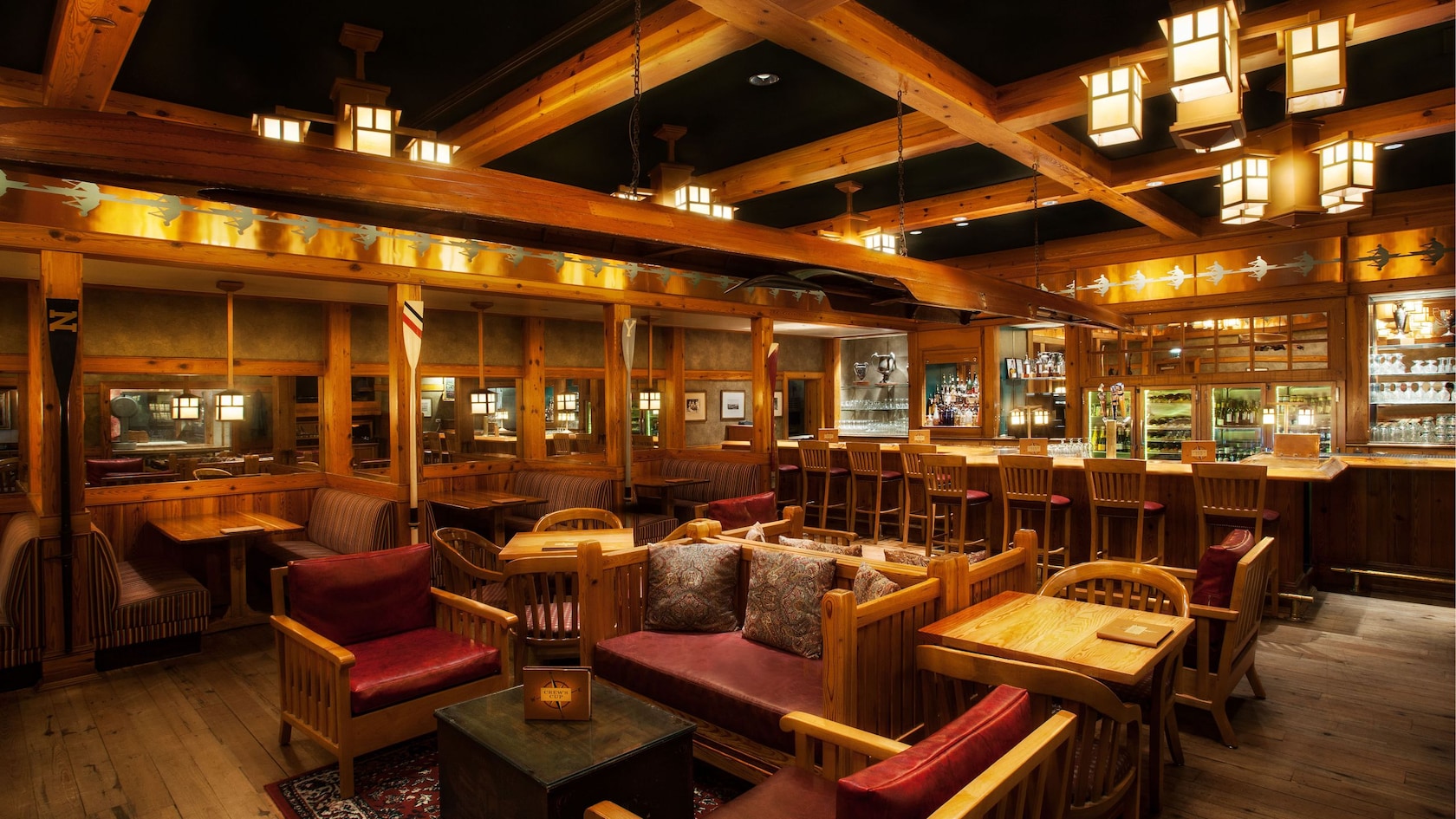 A bar area with several booths and small sitting areas made up of chairs and couches