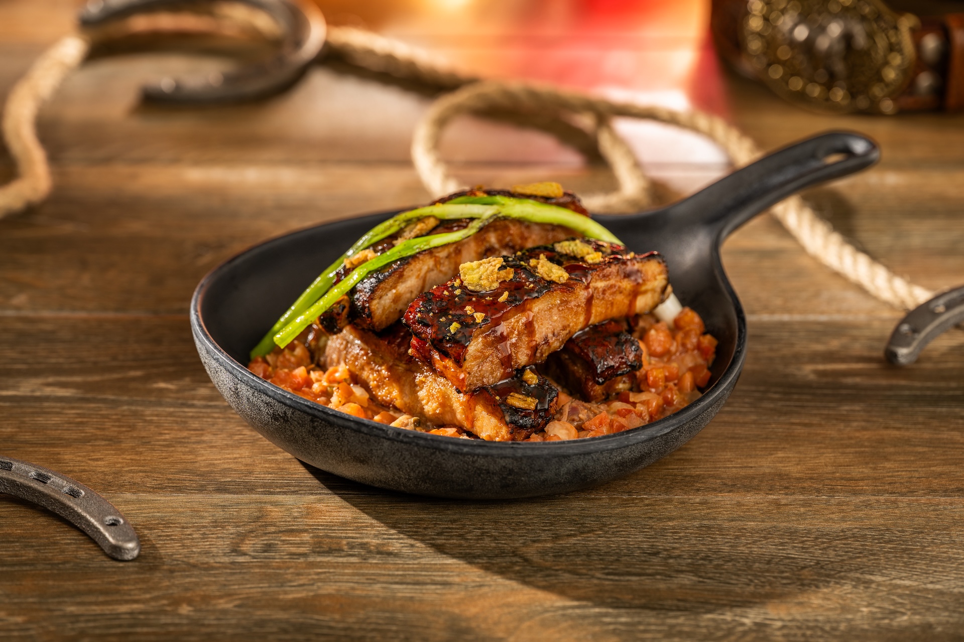 Glazed ribs over cowboy beans in a cast iron skillet