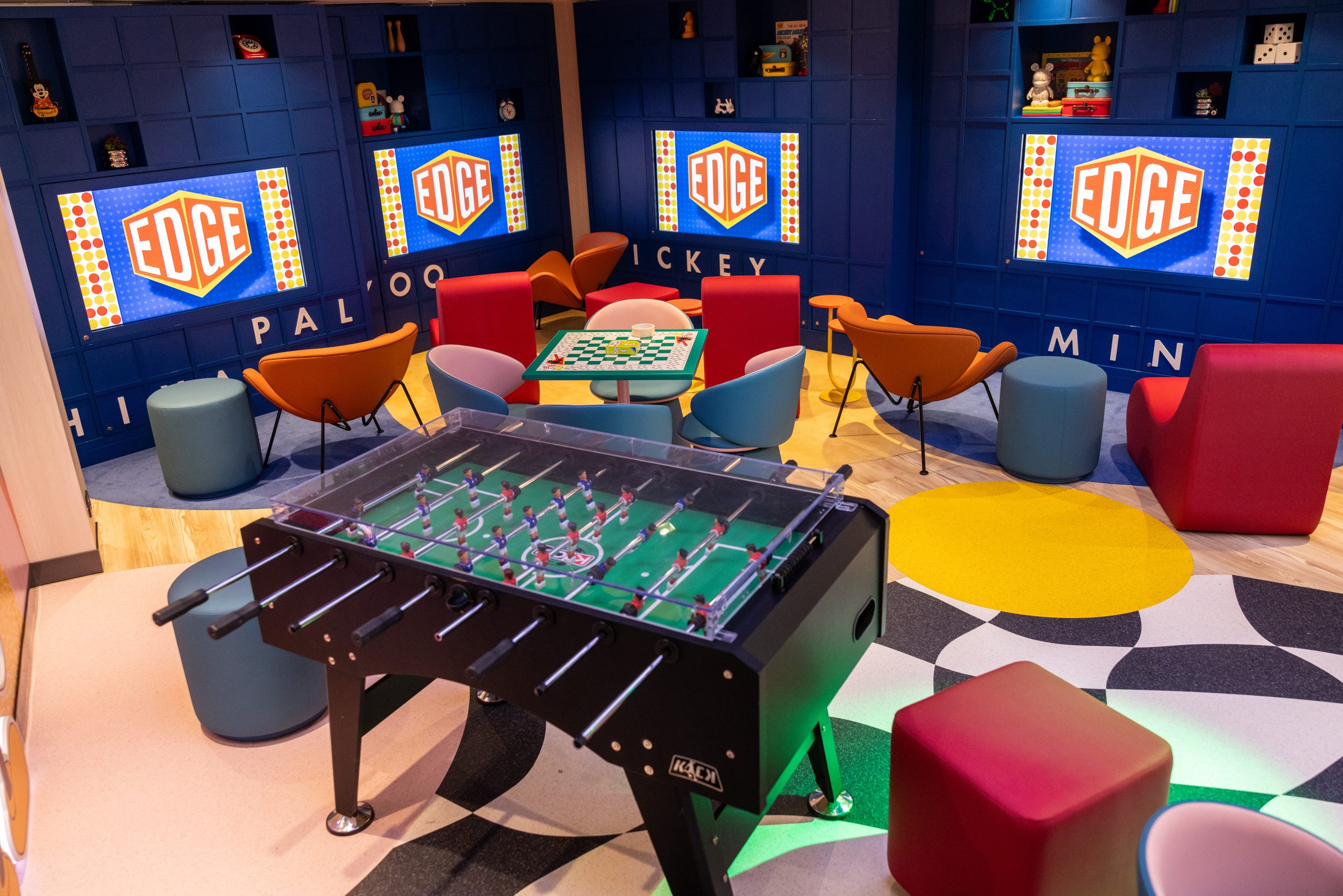 The refreshed Edge tween club aboard a Disney Cruise Line ship, with Edge logos on wall screens, colorful seating and a foosball table