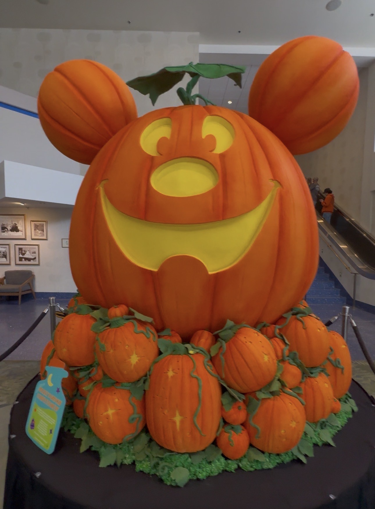 Five-foot Mickey Mouse jack-o'-lantern confection with pumpkin ears sitting on a pile of smaller carved pumpkins and vines at the Disneyland Hotel