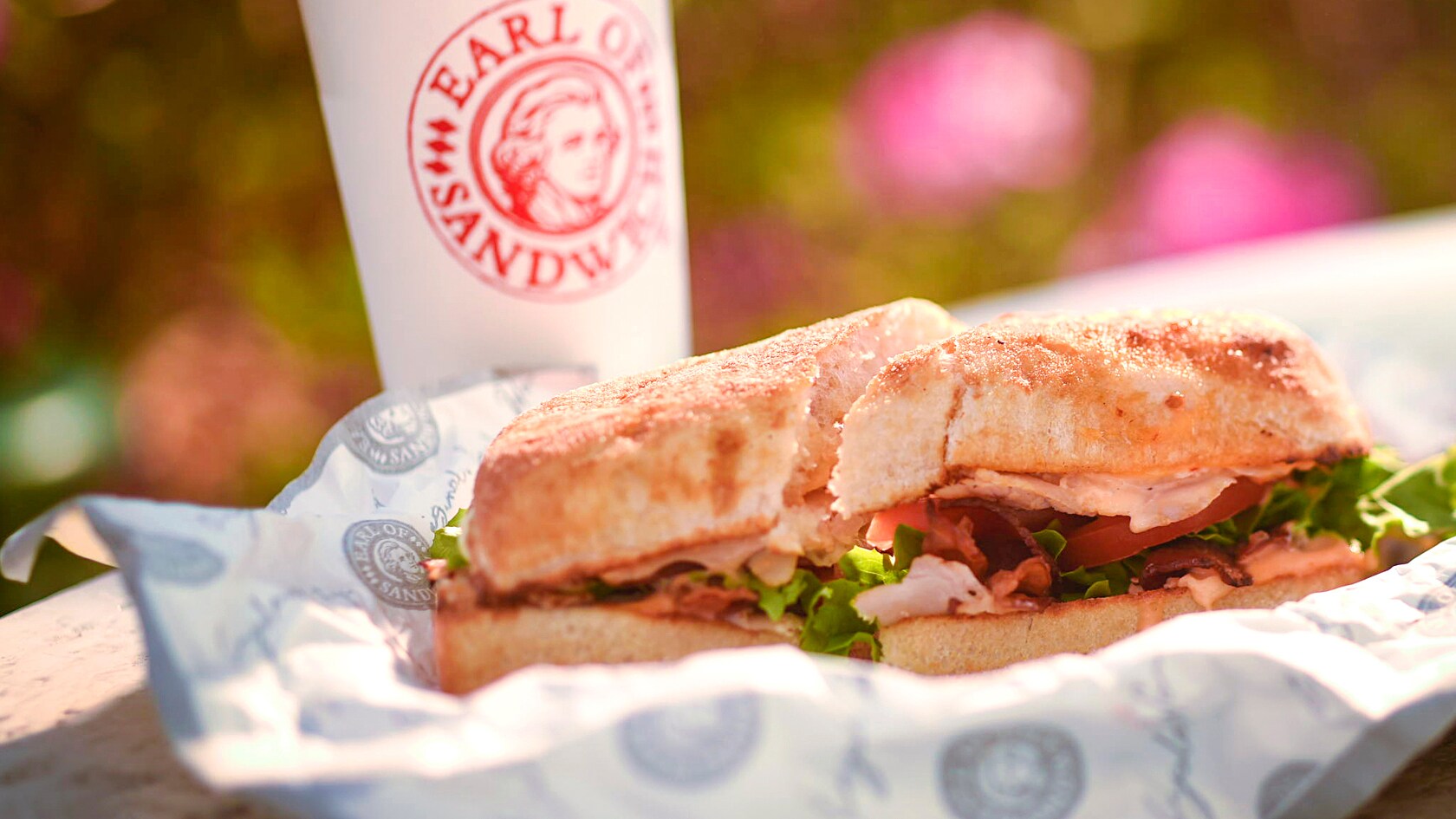 The Earl’s Club sandwich and a fountain soda cup with a straw