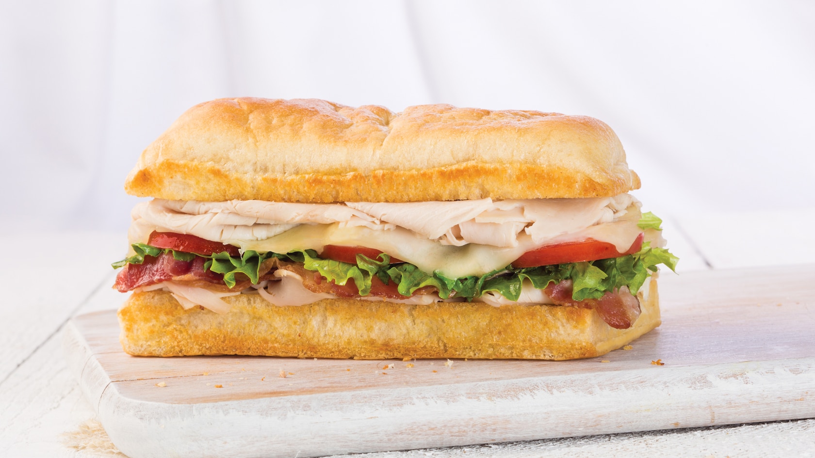 A club sandwich with turkey, bacon, Swiss cheese, lettuce and tomato