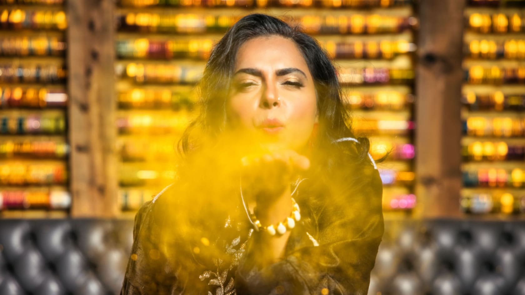 A woman near a wall decorated with bangles