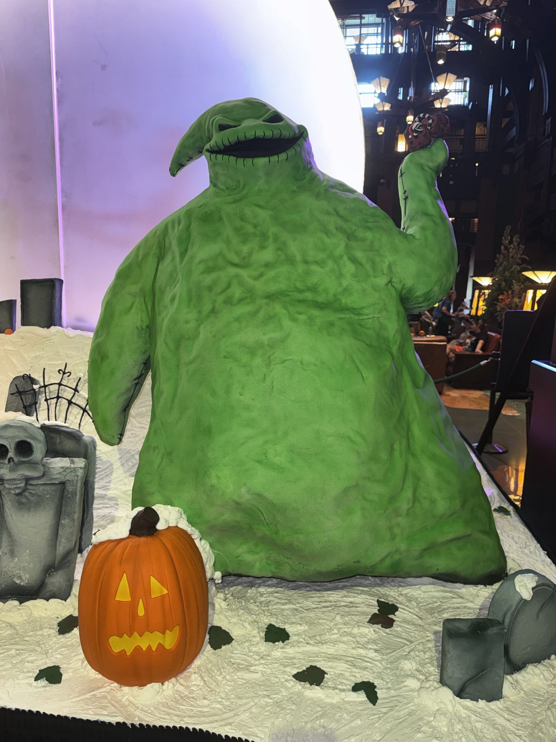 Oogie Boogie confection figure holding up a pair of dice beside tombstones and a jack-o'-lantern at the Grand Californian