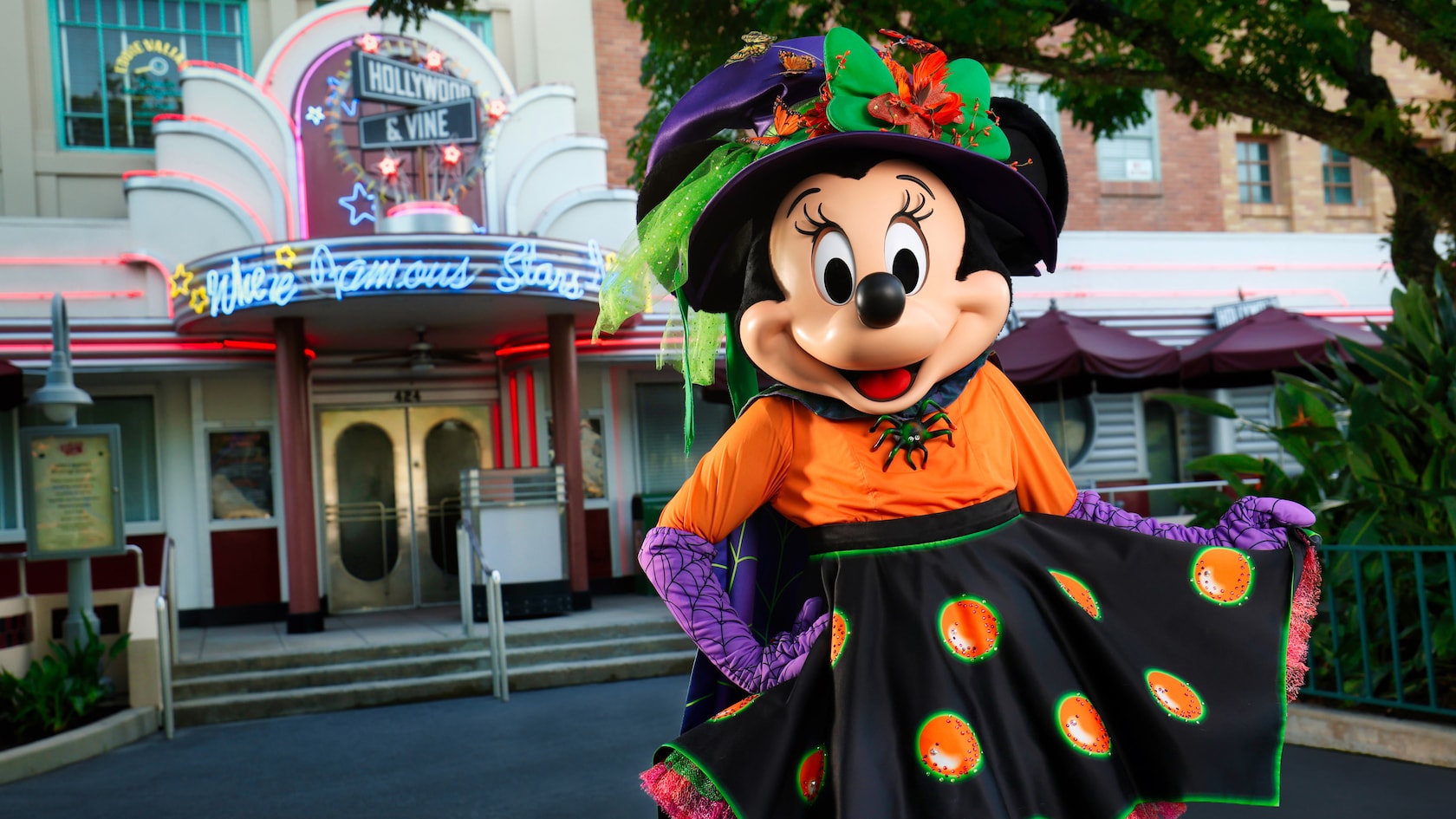Minnie Mouse wearing a Halloween outfit in front of Hollywood & Vine restaurant