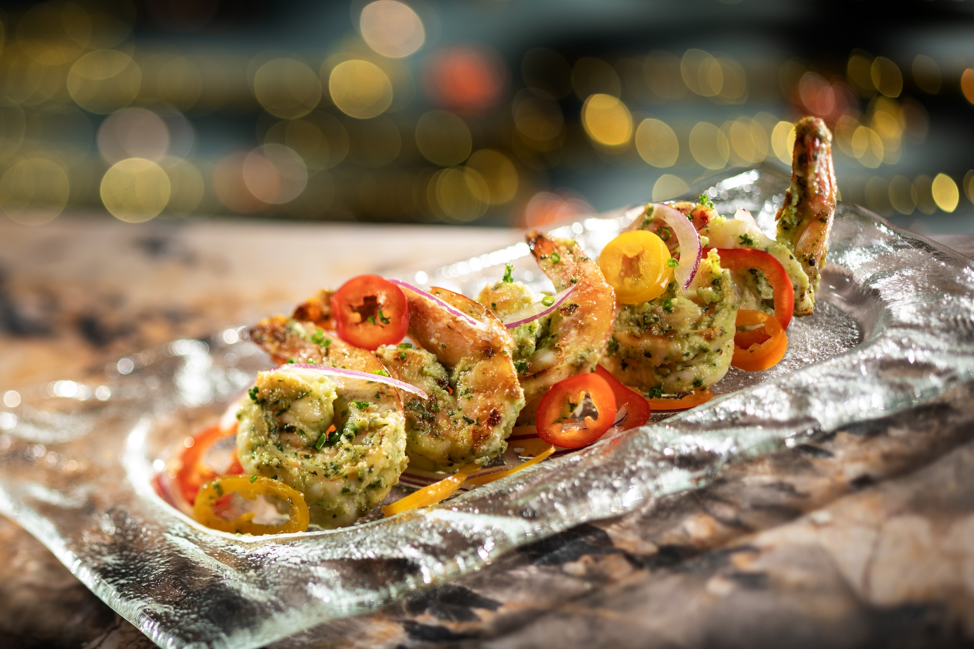 Hurly-Burly's Oven-Roasted Shrimp with herbs and sweet pepper-onion relish on a glass plate