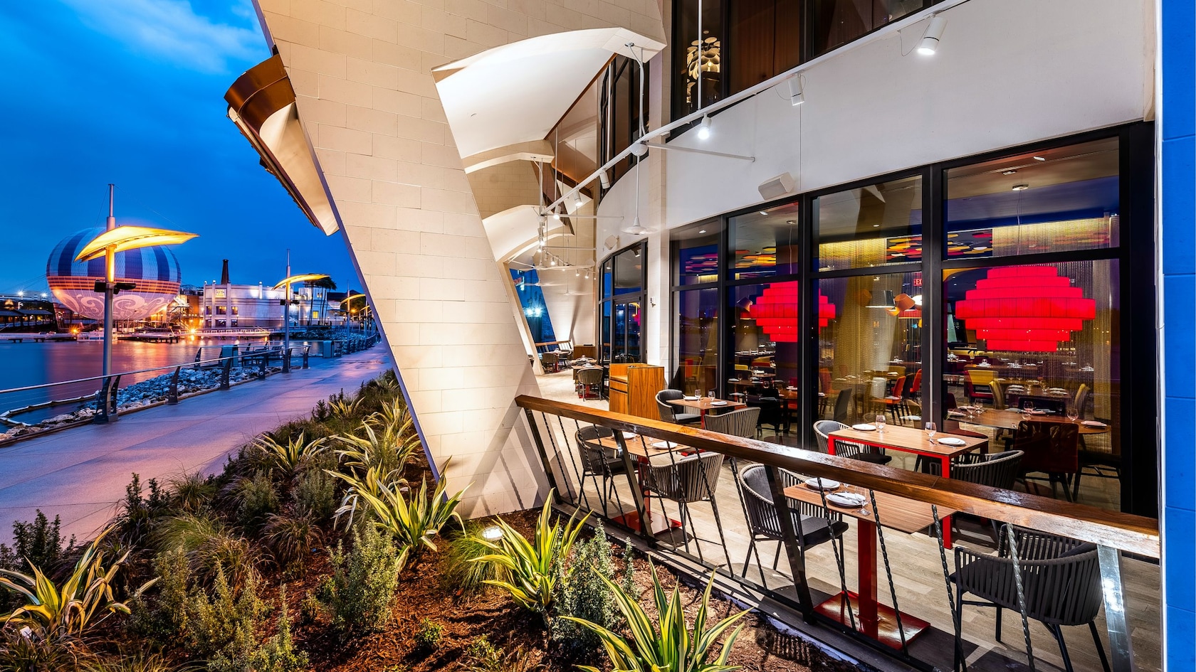 A terrace at Jaleo by José Andrés with tables for 2 people near the lake at Disney Springs
