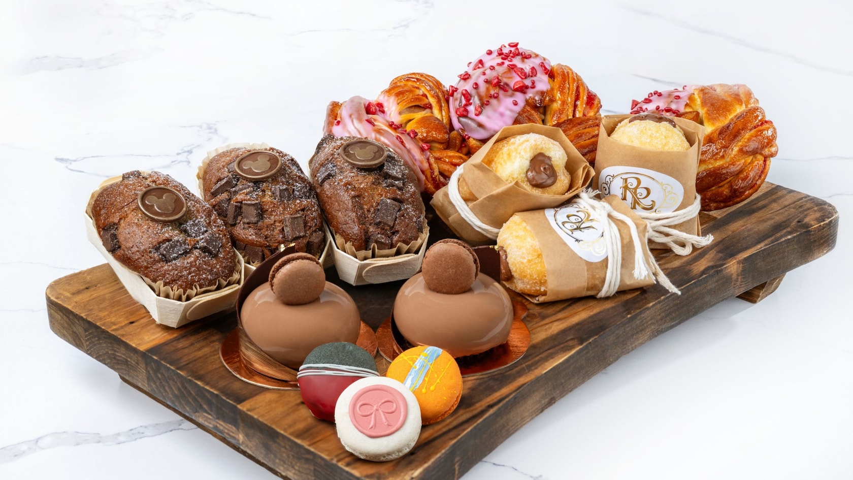 A tray with Banana Bread, Raspberry Brioche, Hazelnut-Chocolate Bomboloni and Trois Chocolat pastries