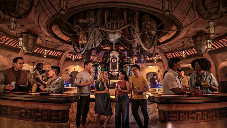 Adults enjoy exotic beverages inside a Star Wars cantina with hoses, tubes and unusual machines