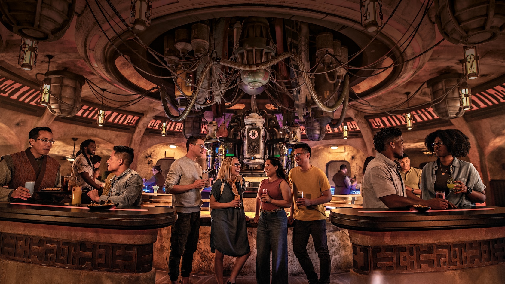 Adults enjoy exotic beverages inside a Star Wars cantina with hoses, tubes and unusual machines