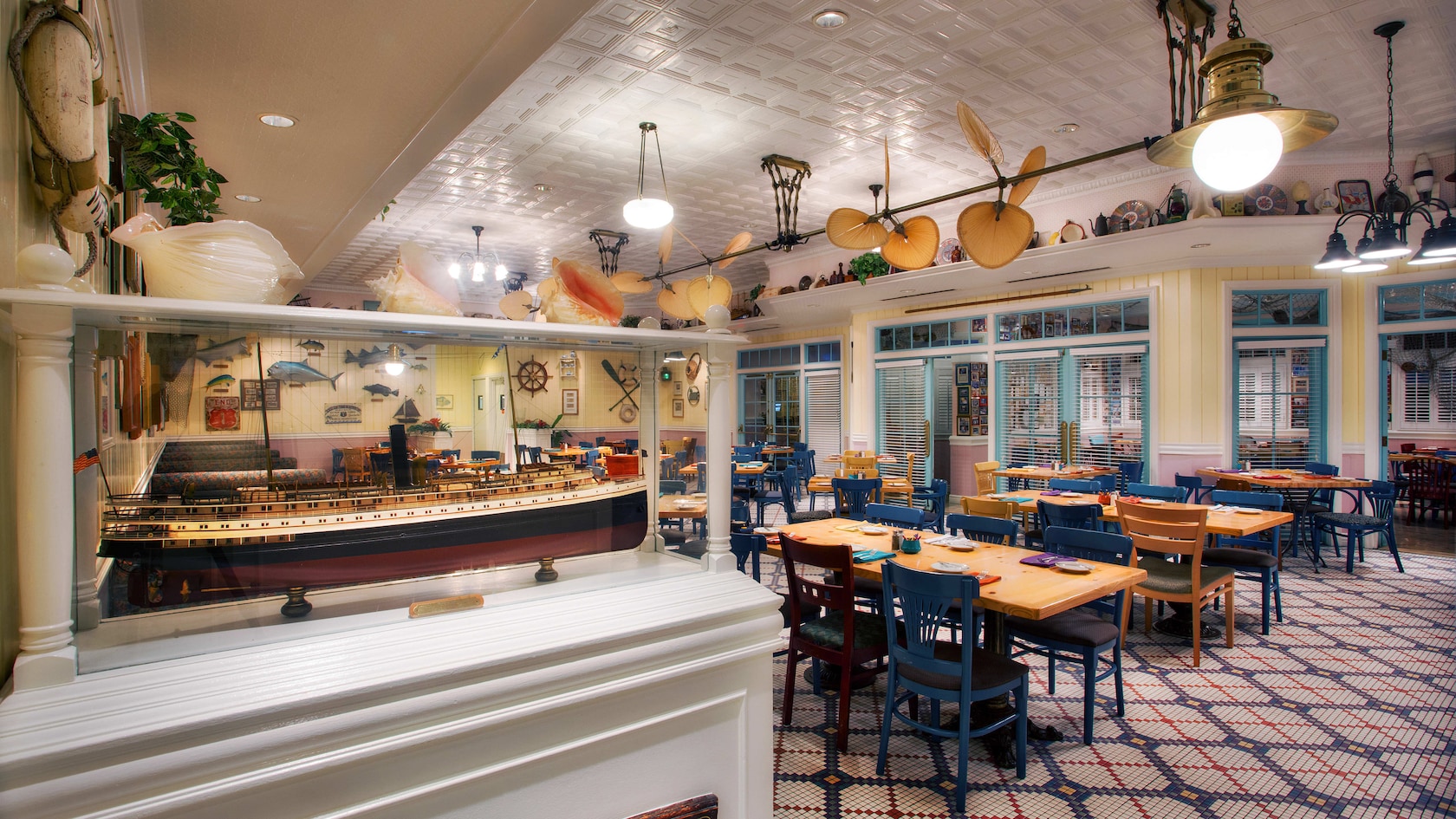 Model ship in a display case near tables and chairs at Olivia's Café