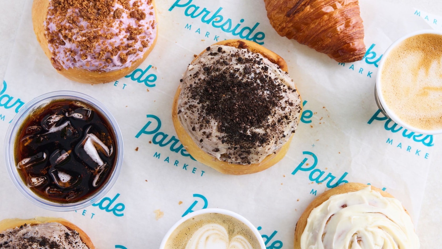 Four frosted donuts, 2 cappuccinos, a croissant and a drink from Sip & Sonder