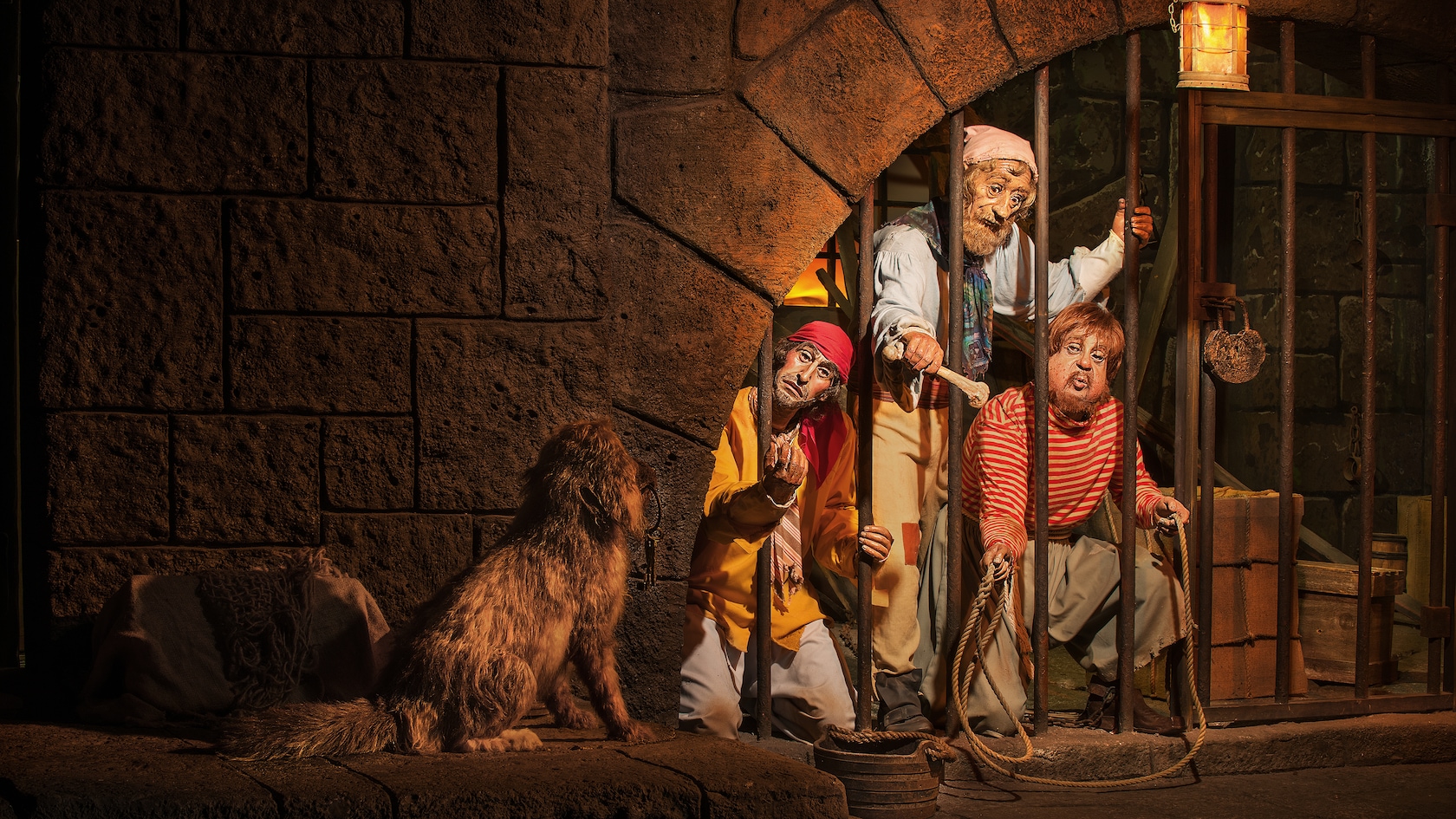 Jailed pirates hold a bone out to a dog in the Pirates of the Caribbean attraction at Magic Kingdom