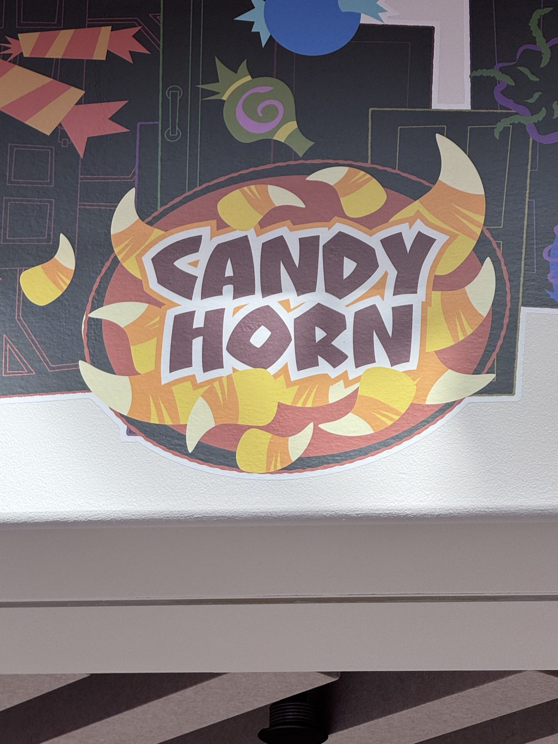 Candy Horn label artwork surrounded by candy corn shaped horns at Pixar Place Hotel