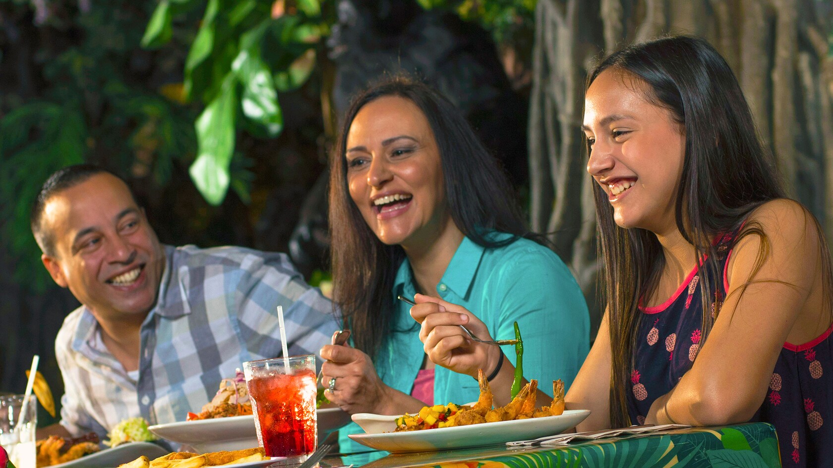 A family of 3 dines at the Rainforest Café at the Disney Springs Marketplace