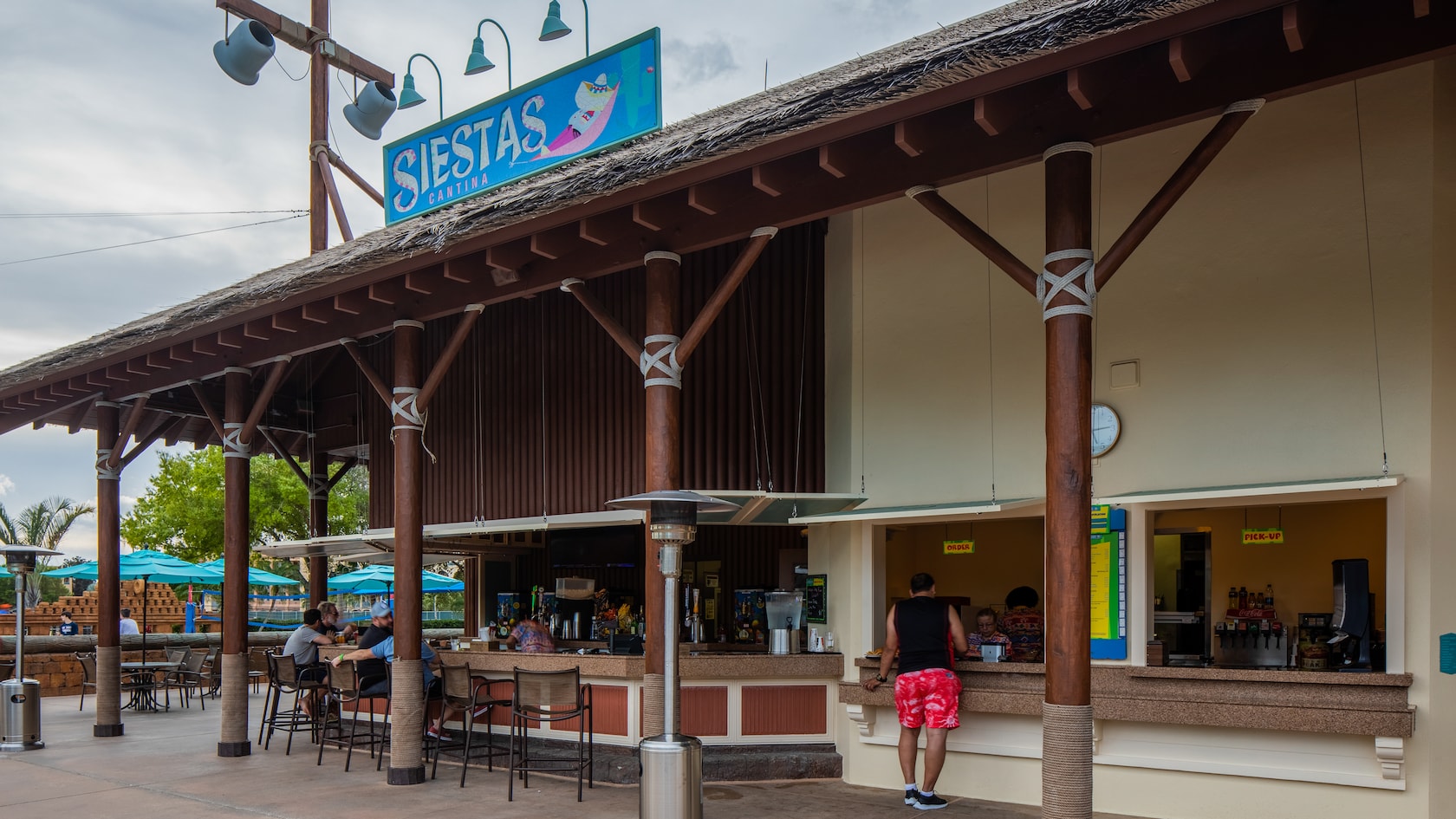 A poolside bar and quick-serve restaurant fashioned to look like a beach hut