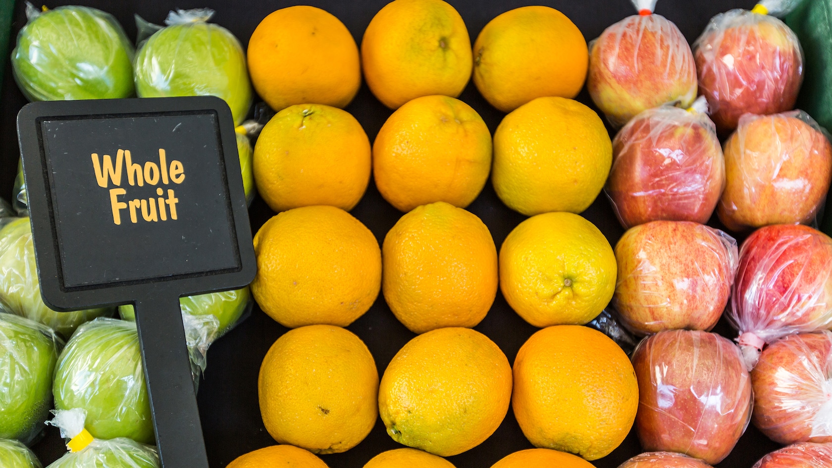 A fruit stand with apples and oranges