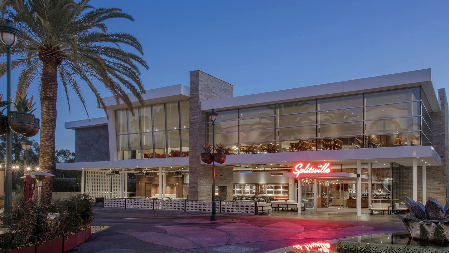 The contemporary exterior of Splitsville with its two stories and the neon Splitsville sign over the entrance