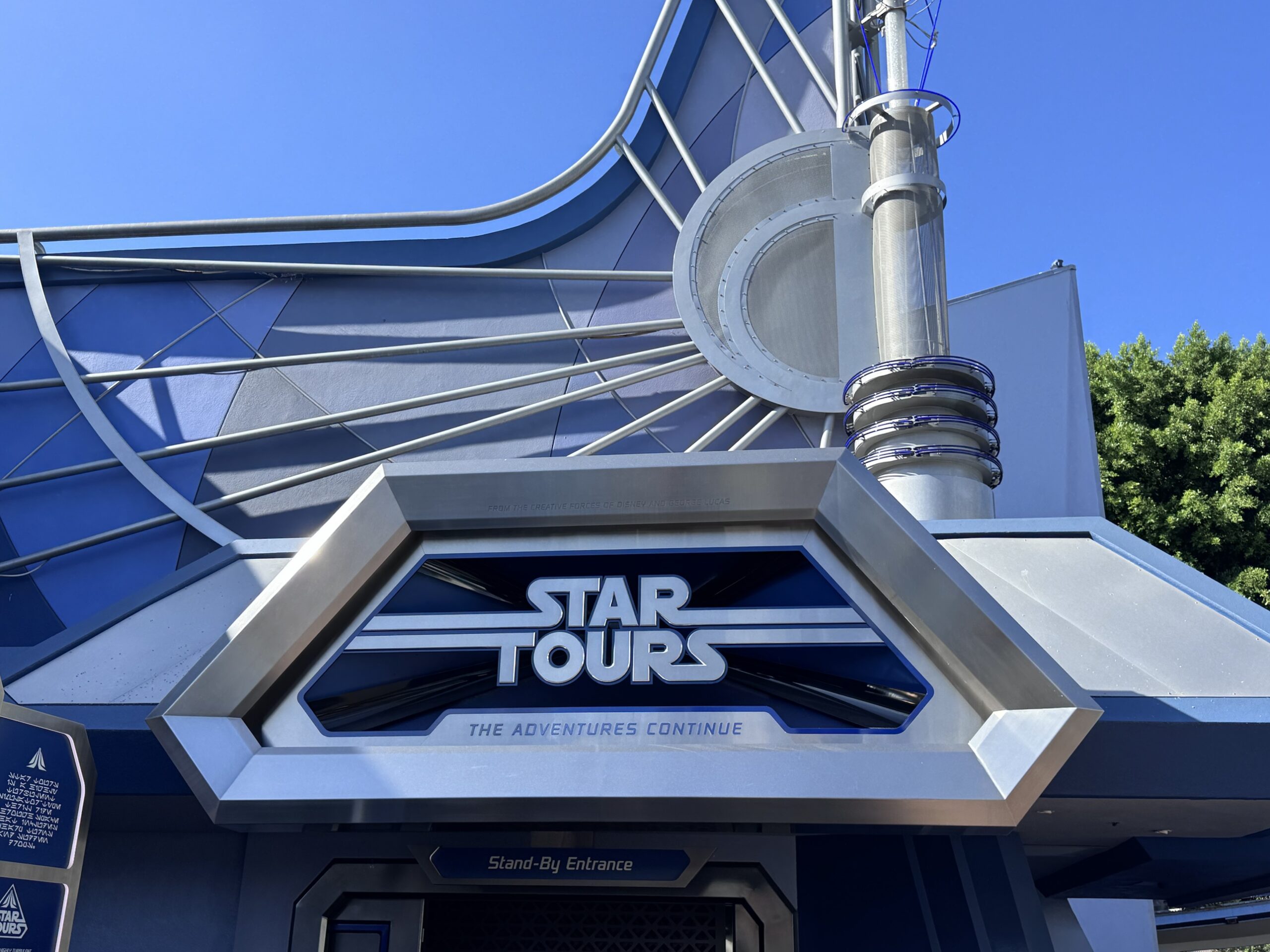 The Star Tours sign above the Stand-By Entrance at Disneyland, still wrapped in its brushed steel frame