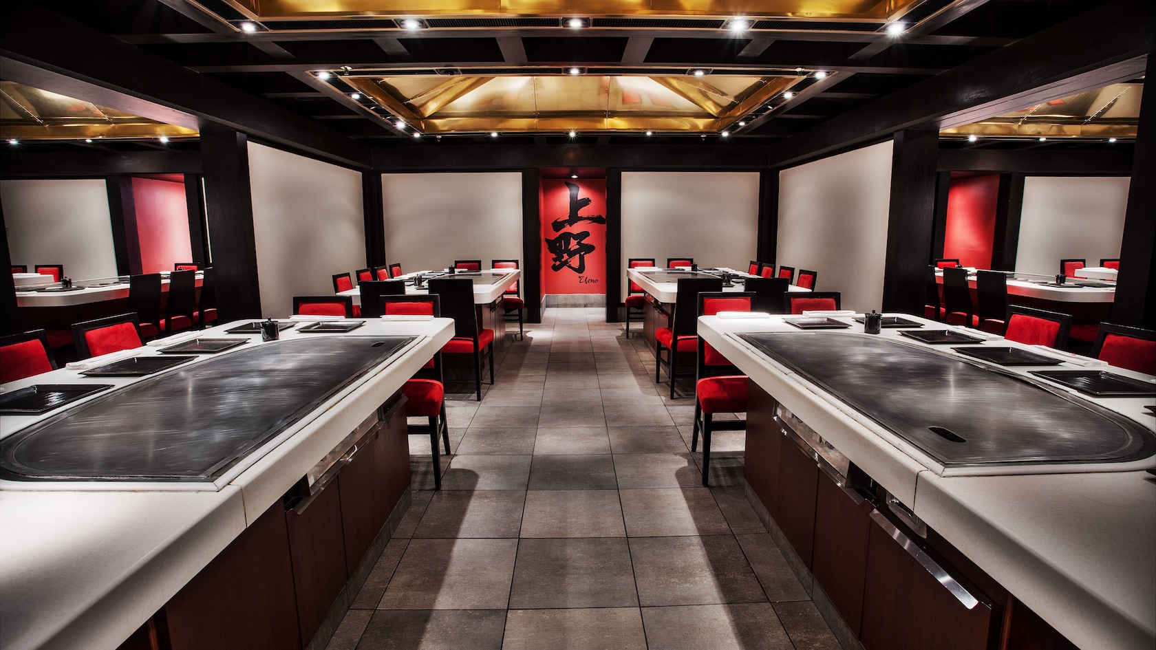 Two dining tables with built-in grills, a ventilation hood and Japanese wall murals