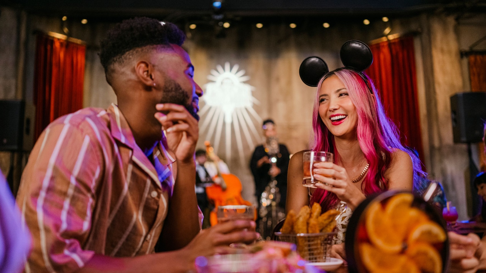 Guests enjoying beverages at a dining table full of dishes at The Edison