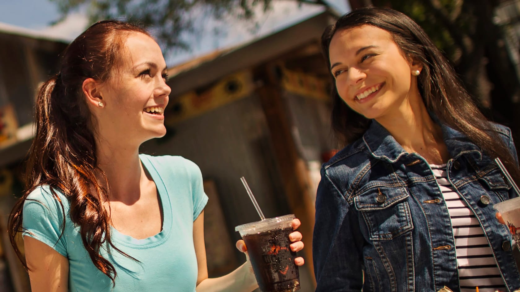 Two females enjoy fountain sodas outside of The Smokehouse