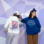 Walt Disney World 55th anniversary white zip-up hoodie with the 55 Magical Years logo and blue pullover hoodie with park logos, with the anniversary ear headband (Disney)