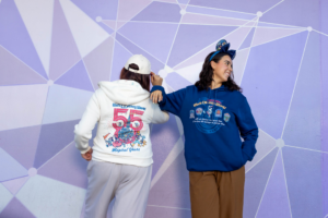 Walt Disney World 55th anniversary white zip-up hoodie with the 55 Magical Years logo and blue pullover hoodie with park logos, with the anniversary ear headband (Disney)