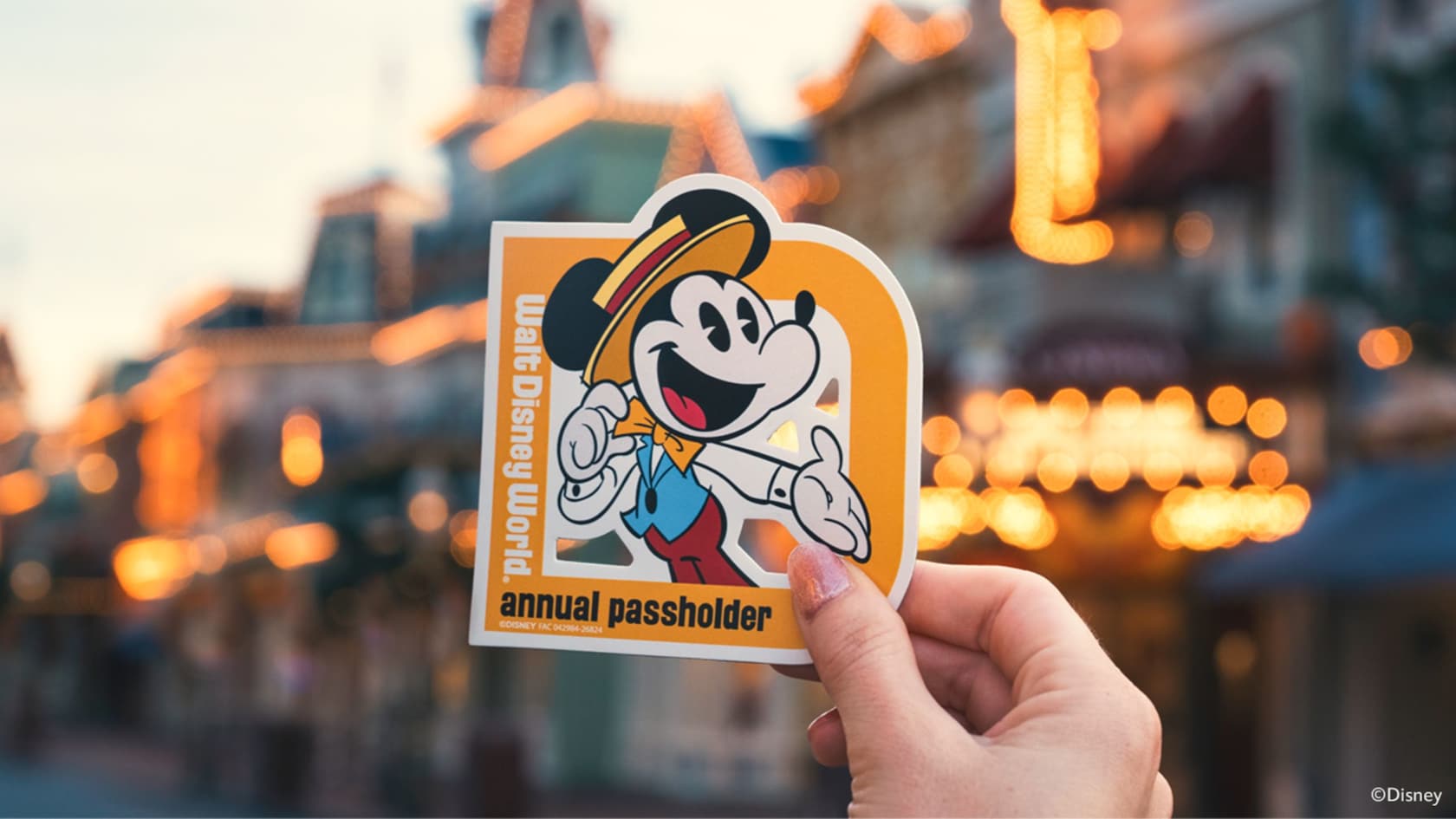 Walt Disney World Annual Passholder renewal magnet showing Mickey Mouse in dapper attire held up on Main Street, U.S.A. (Disney)