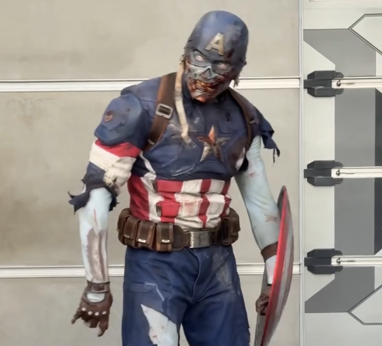 Zombie Captain America in a torn and bloodied suit holding his shield at D23 Night at Oogie Boogie Bash