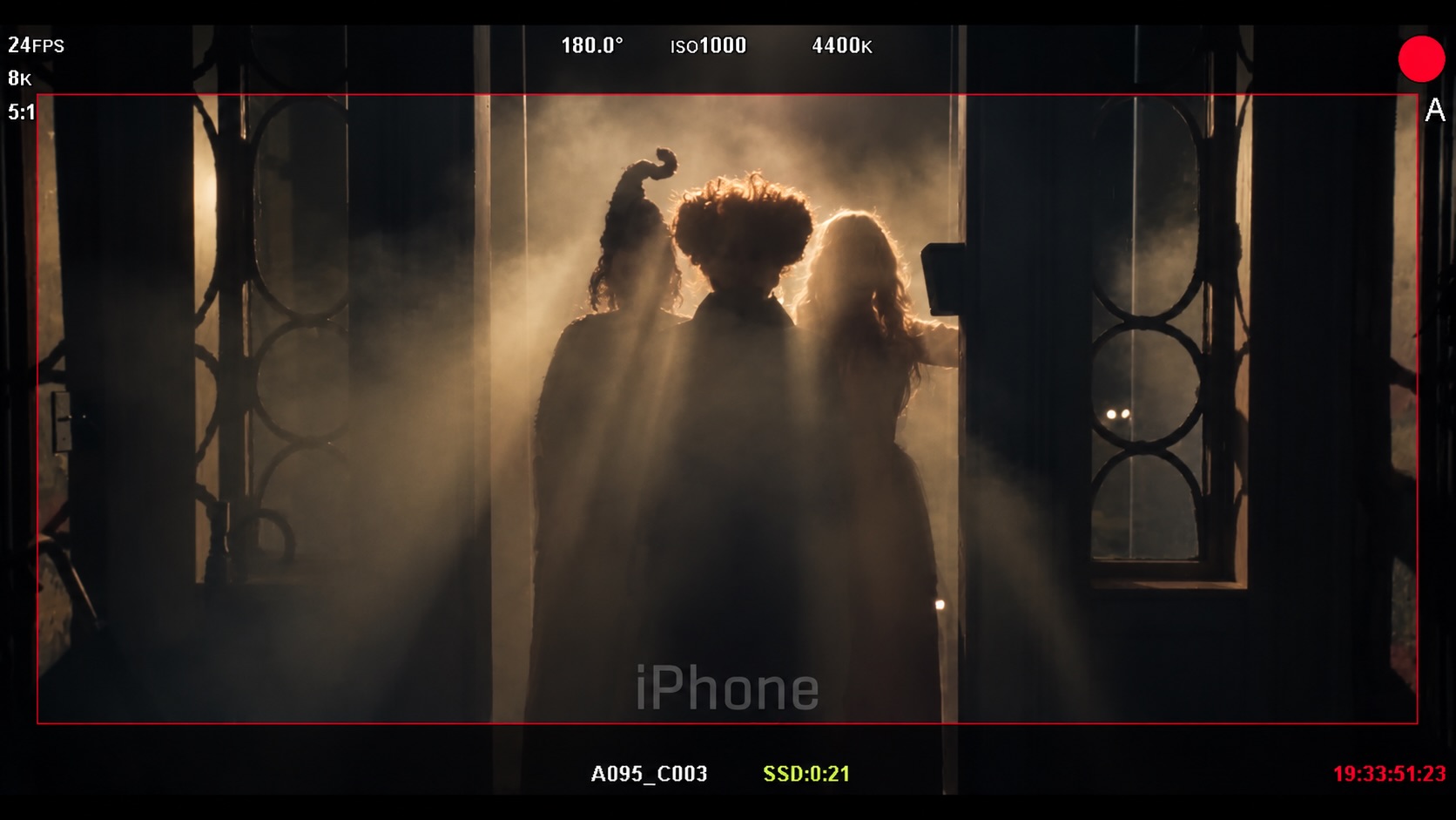 Three silhouettes matching the Sanderson sisters in a smoky, backlit doorway, framed by a camera monitor display, from Bette Midler's Oct. 1 Instagram post