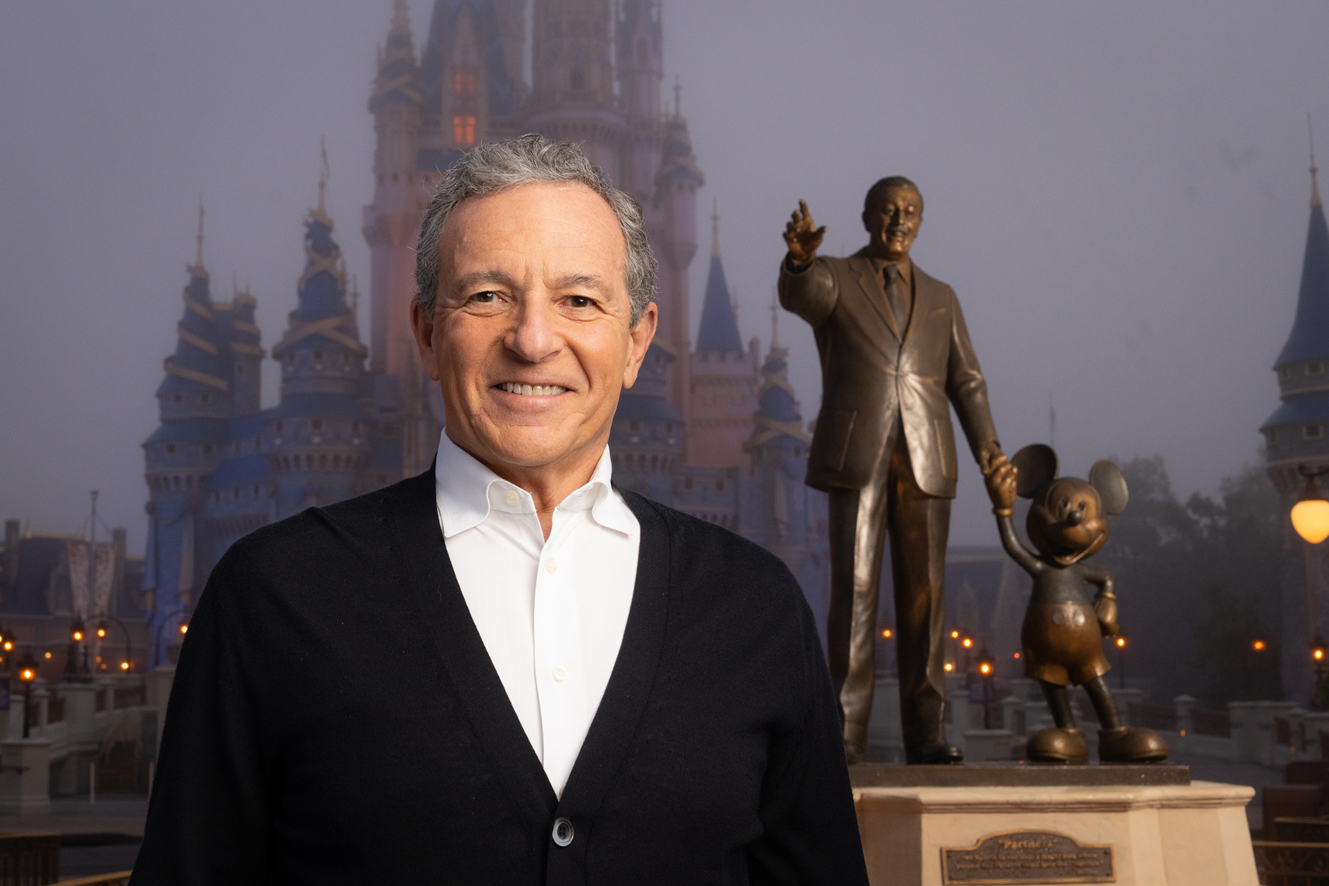 Bob Iger in front of Cinderella Castle and the Partners statue at Magic Kingdom