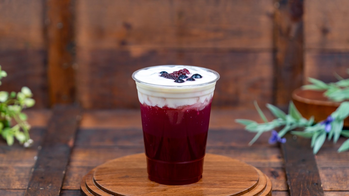 Pomegranate-Blueberry Refresher, a deep red drink with a thick layer of white foam topped with blueberries and blackberries