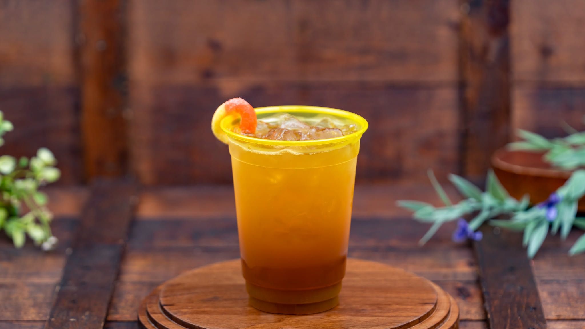 Southern Whiskey Peach Tea, an amber iced drink garnished with a peach gummy ring on the rim