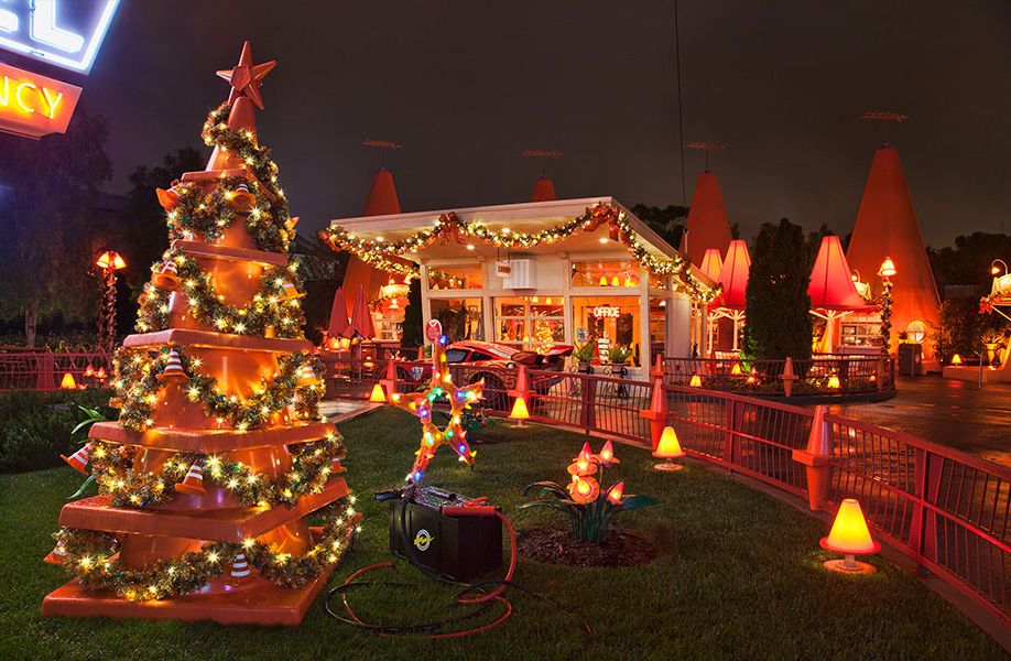 The Cozy Cone Motel in Cars Land decorated for the holidays with garlands, lights and a traffic cone Christmas tree