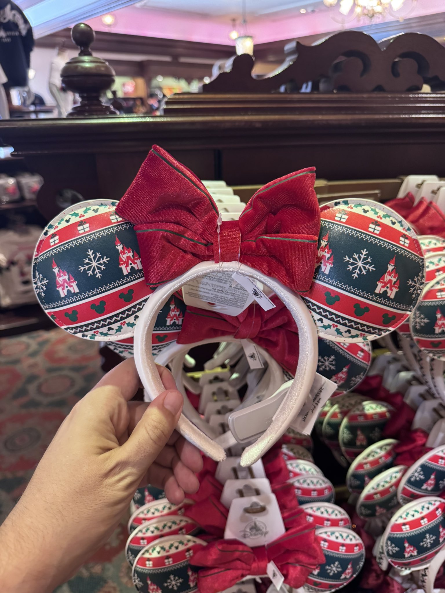 Christmas sweater-pattern Minnie ears with a castle, snowflakes and a red bow at the Emporium at Disneyland