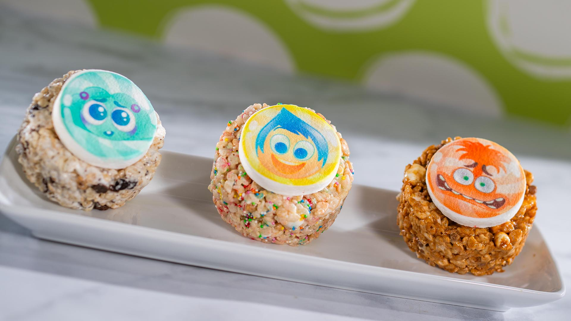 Three Inside Out crisped rice cereal treats topped with Envy, Joy and Anxiety decorations