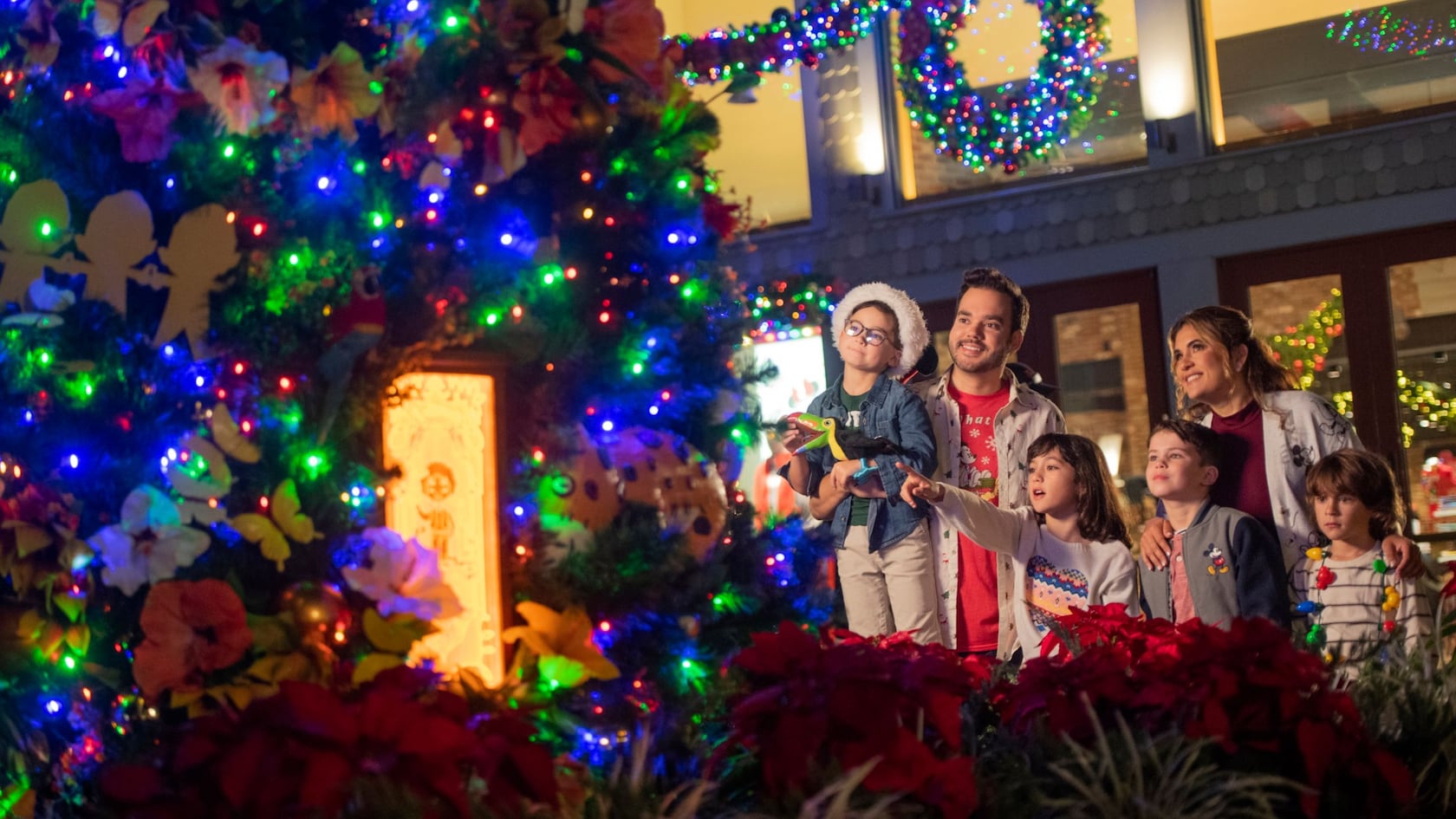 A family admiring a decorated Christmas tree at Disney Springs