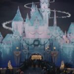 Sleeping Beauty Castle covered in snow and icicles with a swirl of light in Disneyland's 2026 holiday commercial