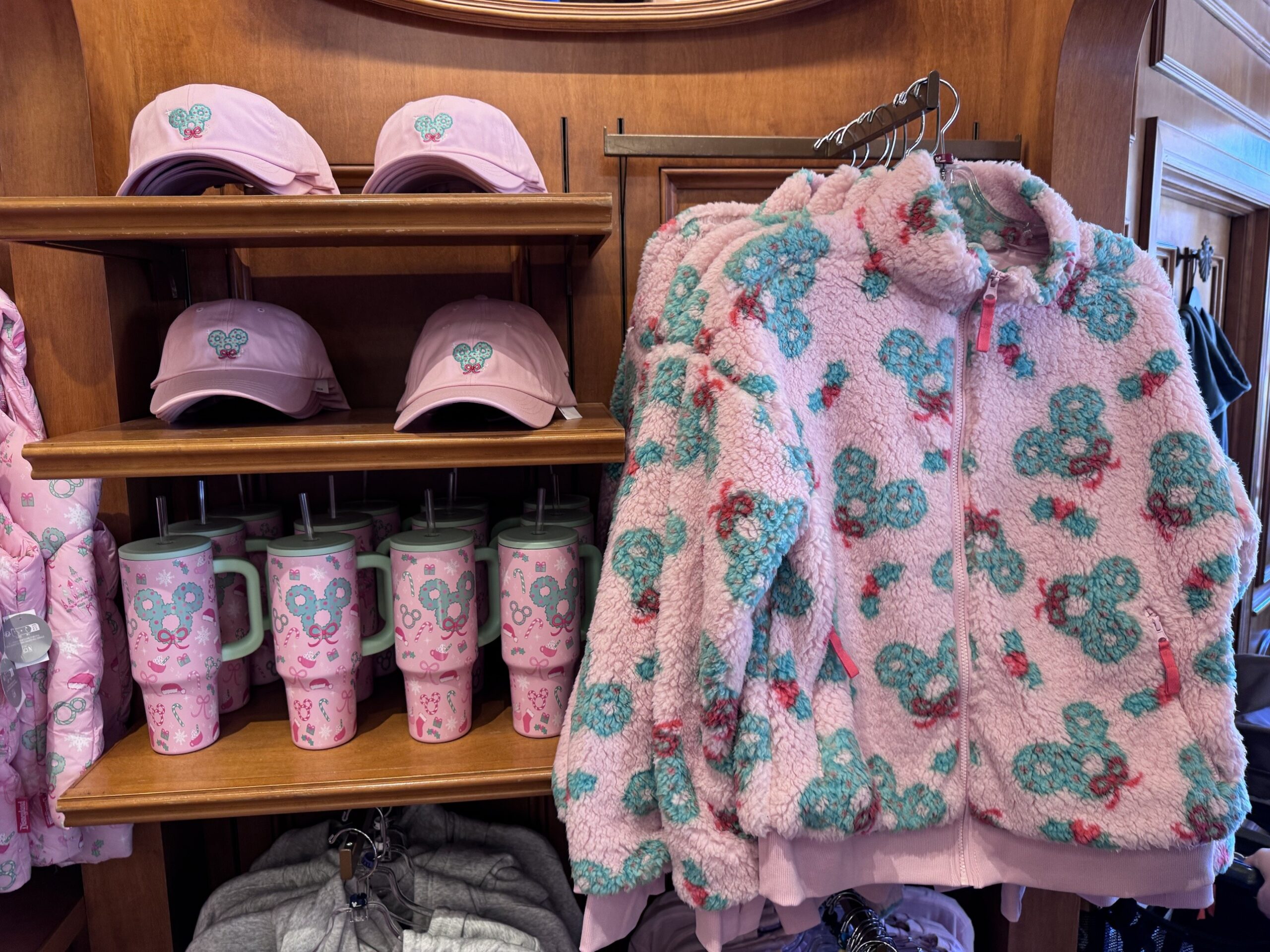 Pink wreath Mickey baseball hats, pink tumblers with mint handles and a pink sherpa jacket covered in teal Mickey wreaths