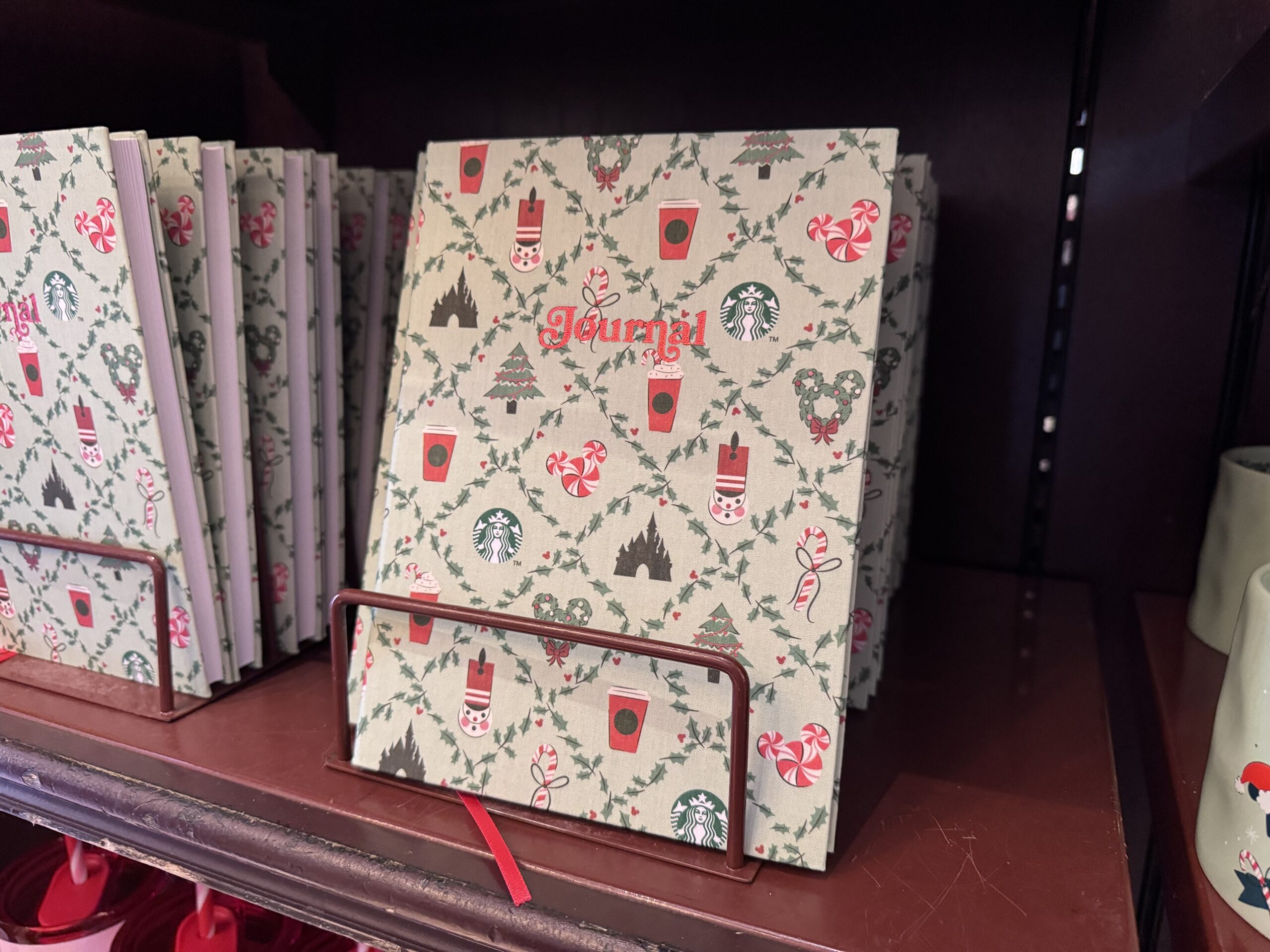 Mint green Starbucks holiday journal with holly pattern, castles, red cups and peppermint Mickey icons